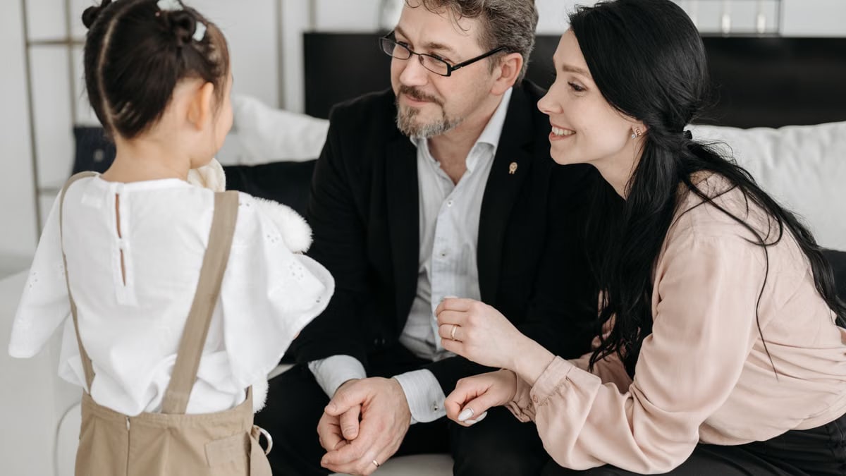 A joyful moment shared between parents and their child in a cozy indoor setting.